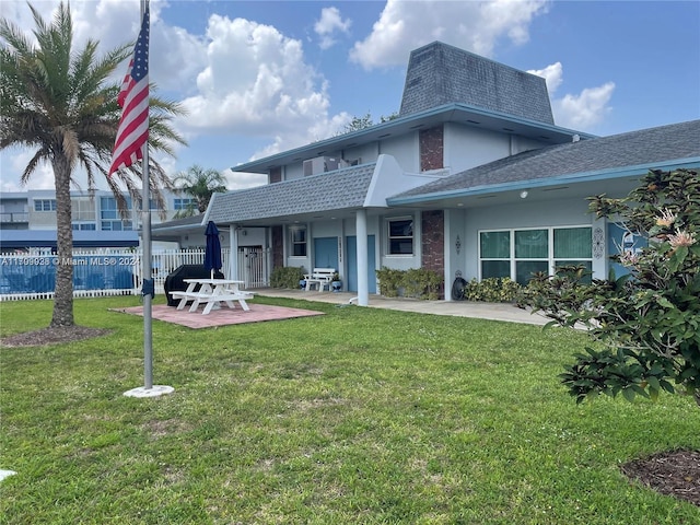 rear view of property featuring a yard and a patio