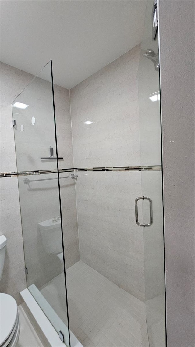 full bath with a stall shower and toilet