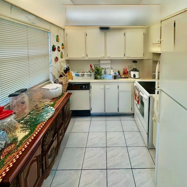 kitchen with a healthy amount of sunlight, white appliances, sink, and light tile patterned floors