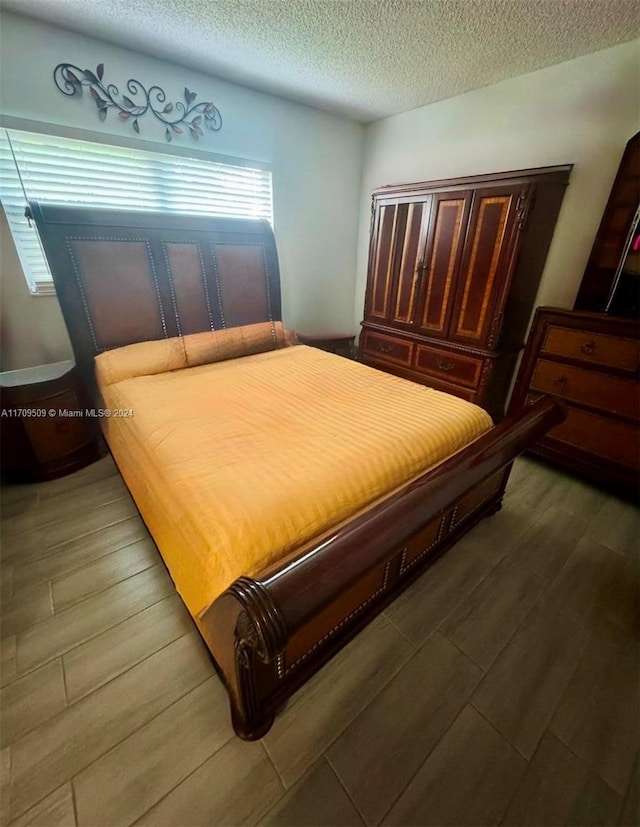 bedroom featuring hardwood / wood-style floors and a textured ceiling