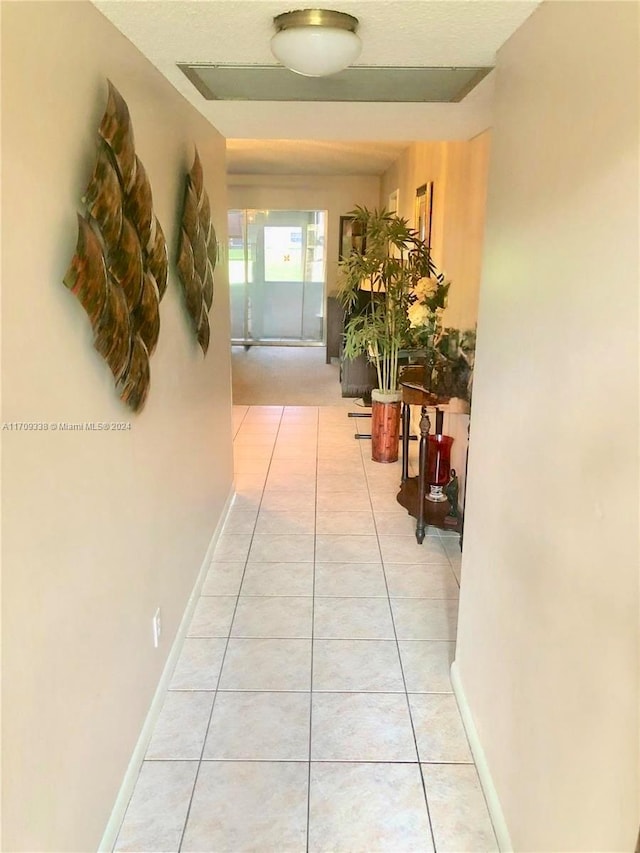 hall featuring light tile patterned flooring