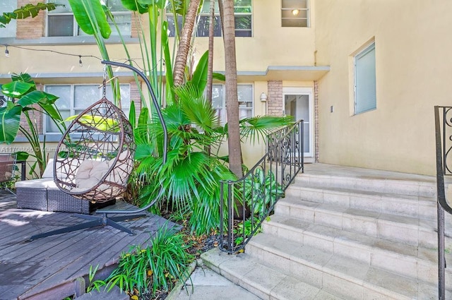 1446 Lenox Ave Unit 2, Miami Beach, FL 33139 - view of exterior entry with stucco siding and a wooden deck