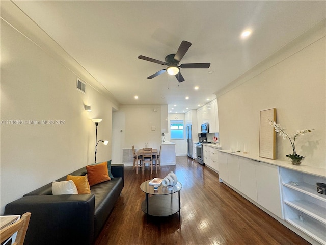 living room with dark hardwood / wood-style floors, ceiling fan, and ornamental molding