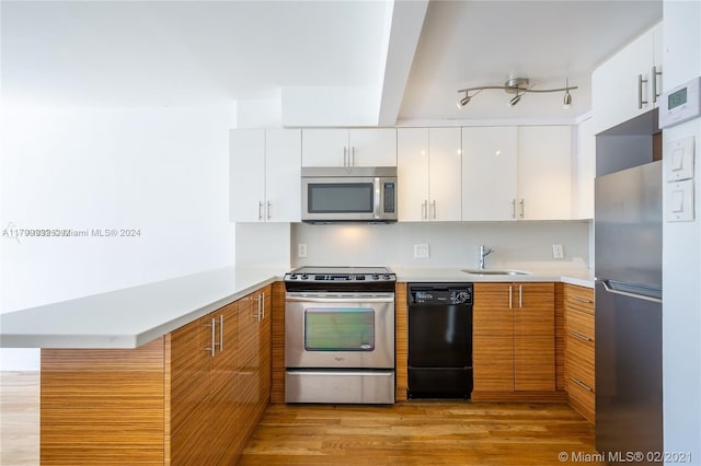 kitchen with appliances with stainless steel finishes, sink, light hardwood / wood-style flooring, beamed ceiling, and white cabinetry