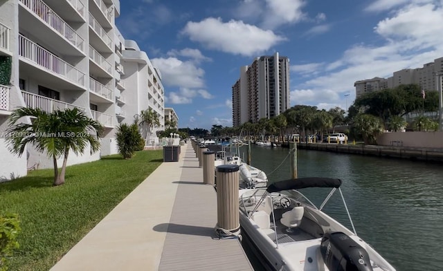 view of dock featuring a water view and a yard