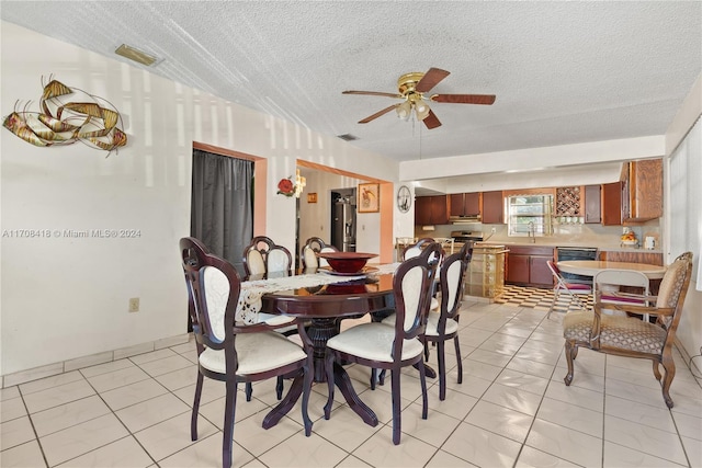 tiled dining area featuring ceiling fan and a textured ceiling