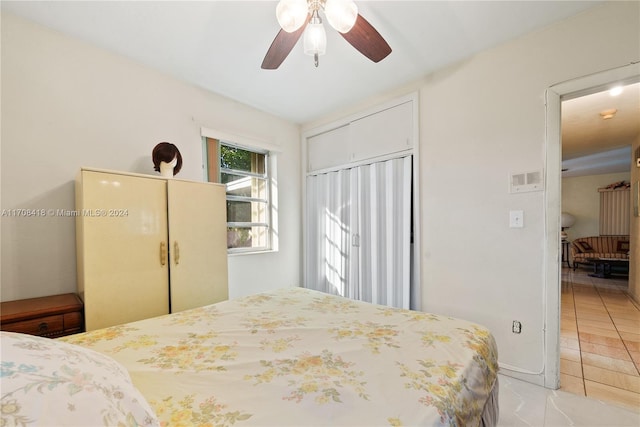 bedroom featuring light tile patterned floors, a closet, and ceiling fan