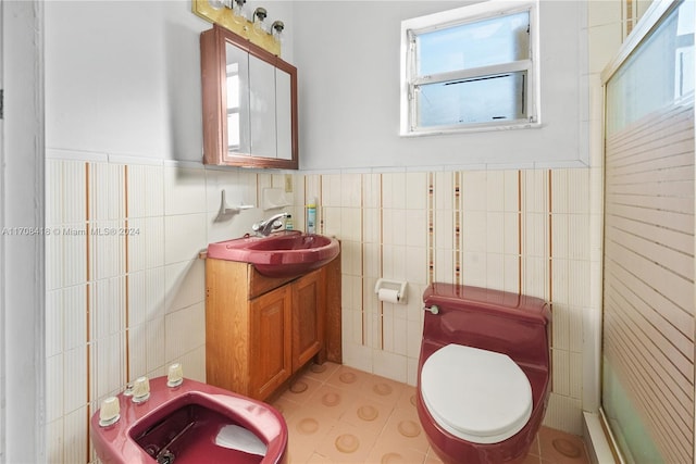 bathroom featuring vanity, a bidet, toilet, and tile walls