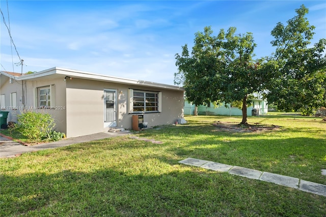 single story home featuring a front lawn