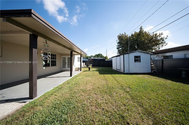 view of yard featuring a patio area, a shed, and french doors