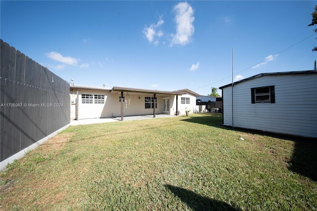 back of house with a yard and a patio