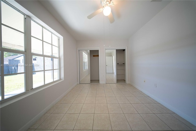 unfurnished bedroom with multiple windows, light tile patterned floors, and ceiling fan