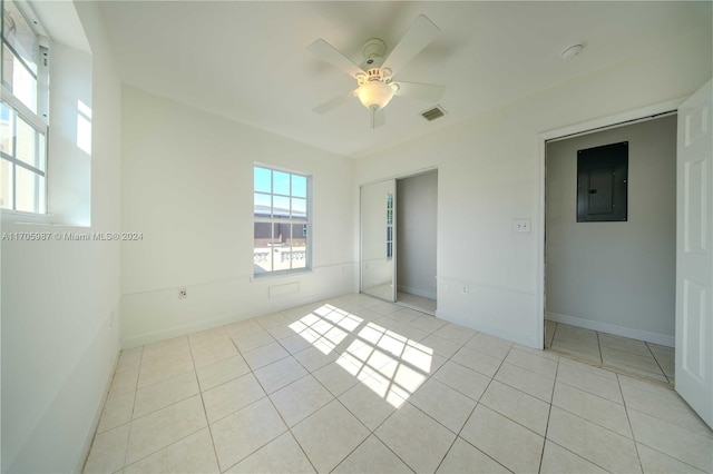 spare room featuring light tile patterned floors, electric panel, and ceiling fan