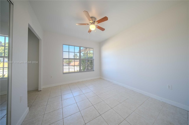 tiled spare room with ceiling fan