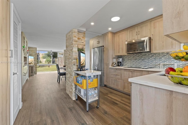 kitchen featuring dark hardwood / wood-style flooring, light brown cabinetry, backsplash, and appliances with stainless steel finishes