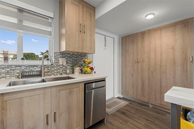 kitchen featuring light brown cabinetry, dark hardwood / wood-style flooring, backsplash, stainless steel dishwasher, and sink