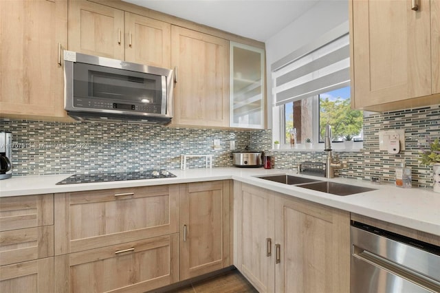 kitchen with light brown cabinets, stainless steel appliances, tasteful backsplash, and sink