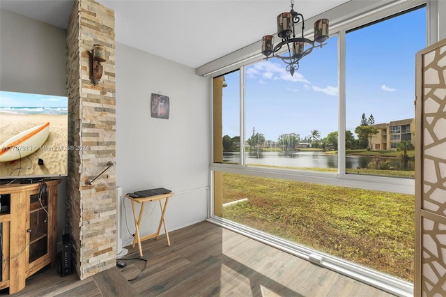 sunroom / solarium with a water view and a notable chandelier