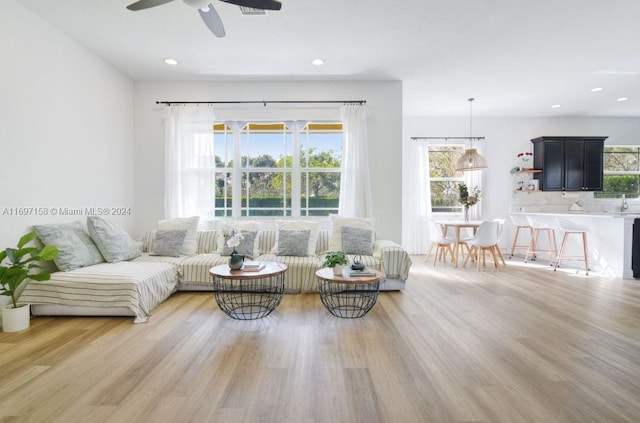 living room with light hardwood / wood-style flooring and ceiling fan