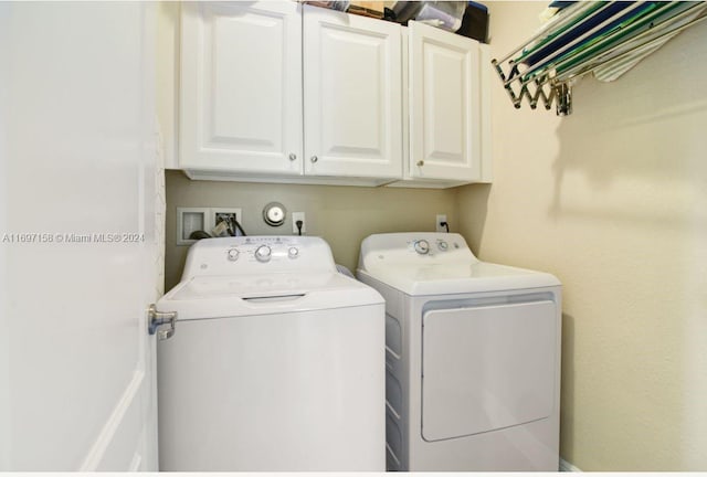 laundry room featuring washing machine and dryer and cabinets