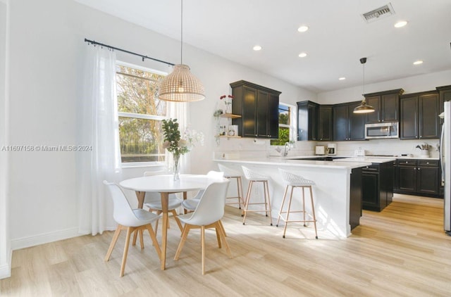 kitchen featuring a healthy amount of sunlight, stainless steel appliances, and decorative light fixtures