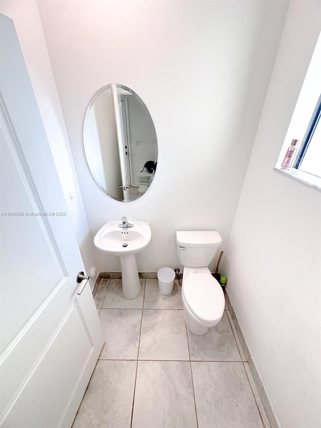 bathroom featuring tile patterned flooring, toilet, and sink