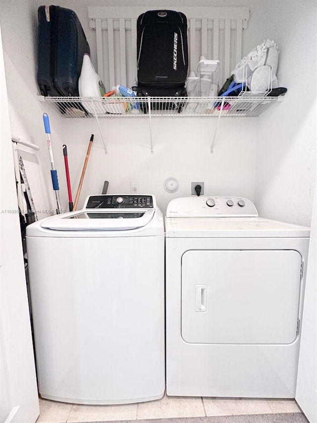 clothes washing area with separate washer and dryer and tile patterned floors