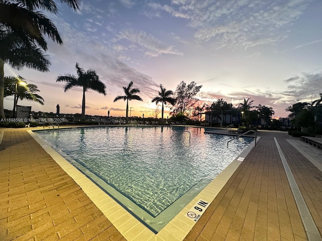 pool at dusk featuring a patio area