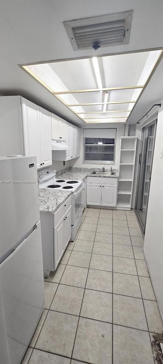 kitchen featuring white cabinets, light stone counters, white appliances, and light tile patterned floors