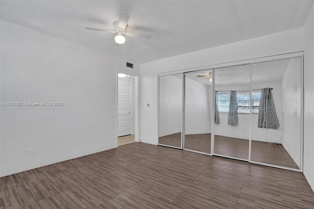 unfurnished bedroom with ceiling fan, a textured ceiling, and a closet