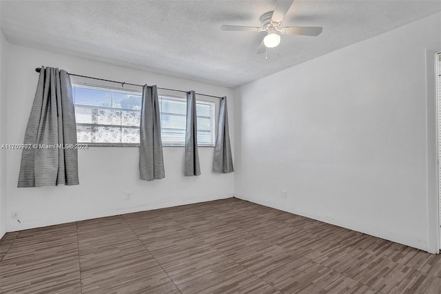 unfurnished room with ceiling fan and a textured ceiling