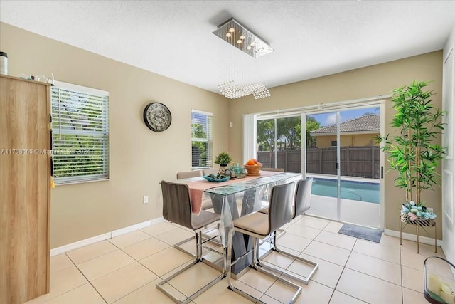 dining area featuring light tile patterned flooring and a textured ceiling