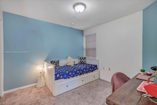 bedroom with light colored carpet and a textured ceiling