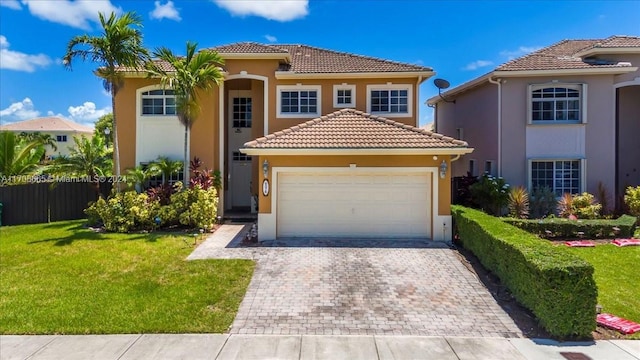 mediterranean / spanish-style home featuring a garage and a front lawn