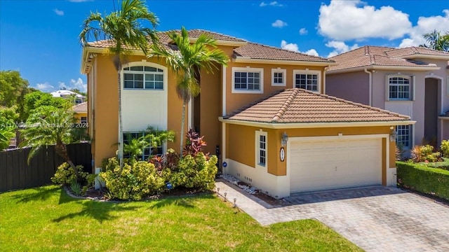 mediterranean / spanish home featuring a garage and a front lawn