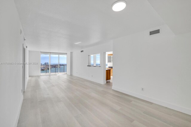 335 S Biscayne Blvd Unit 4109, Miami, FL 33131 - unfurnished living room featuring light wood-style flooring, baseboards, and visible vents