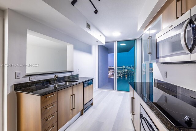 335 S Biscayne Blvd Unit 4109, Miami, FL 33131 - kitchen with black electric cooktop, expansive windows, stainless steel microwave, a sink, and dishwasher