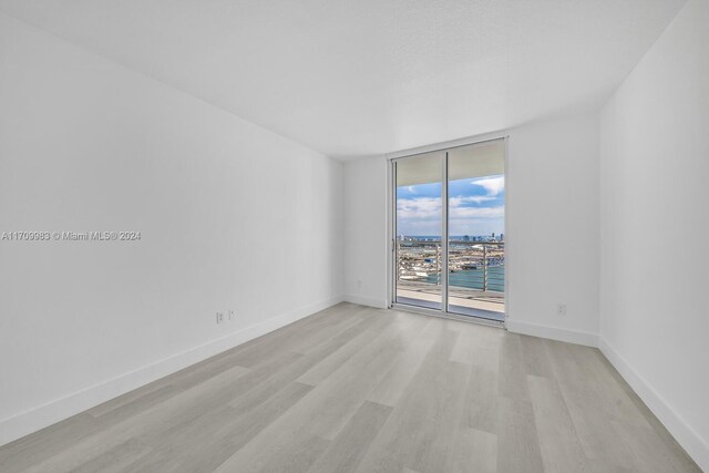 335 S Biscayne Blvd Unit 4109, Miami, FL 33131 - spare room featuring baseboards, floor to ceiling windows, and light wood-type flooring