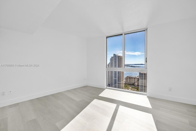 335 S Biscayne Blvd Unit 4109, Miami, FL 33131 - unfurnished room with expansive windows, wood finished floors, a view of city, and baseboards