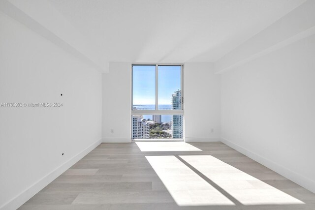 335 S Biscayne Blvd Unit 4109, Miami, FL 33131 - unfurnished room featuring baseboards, floor to ceiling windows, a view of city, and light wood finished floors