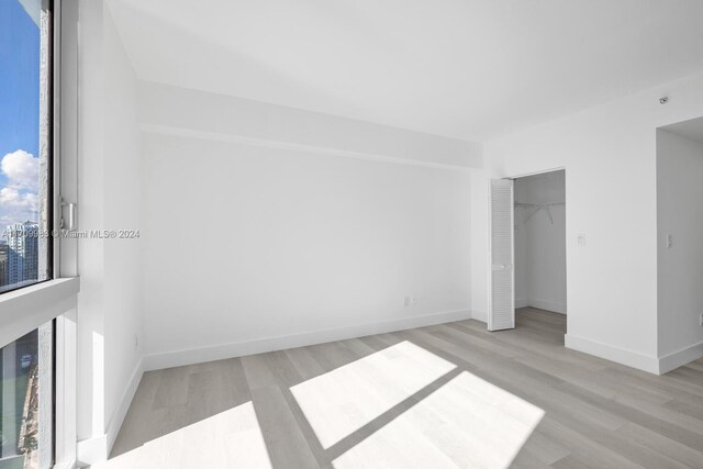 335 S Biscayne Blvd Unit 4109, Miami, FL 33131 - unfurnished bedroom with baseboards, a closet, and light wood-style floors