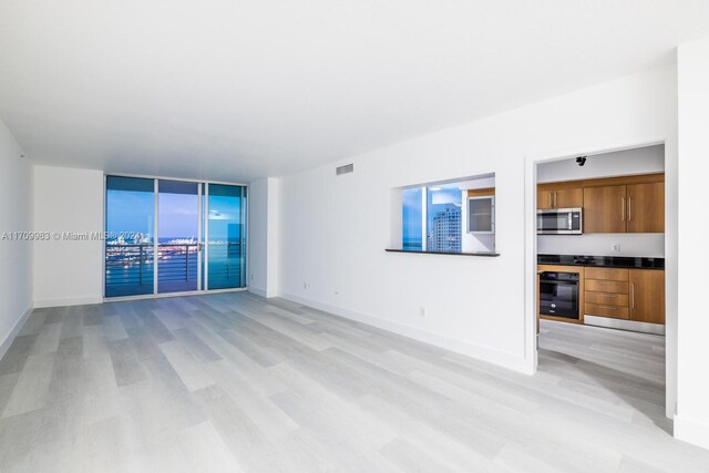 335 S Biscayne Blvd Unit 4109, Miami, FL 33131 - unfurnished living room featuring baseboards, visible vents, and light wood-type flooring