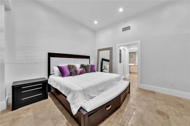 bedroom featuring a high ceiling and ensuite bath