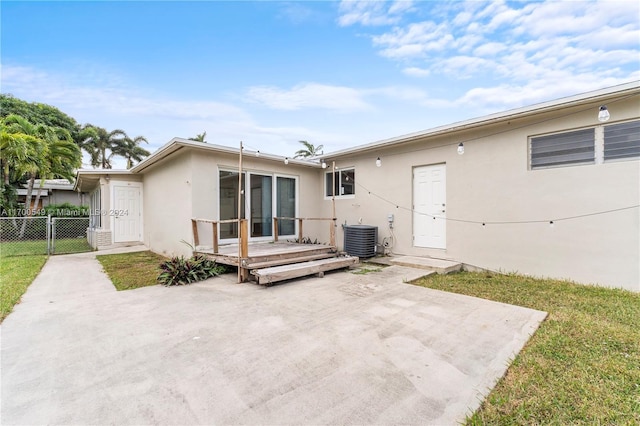 back of property featuring cooling unit, a patio area, a yard, and a deck