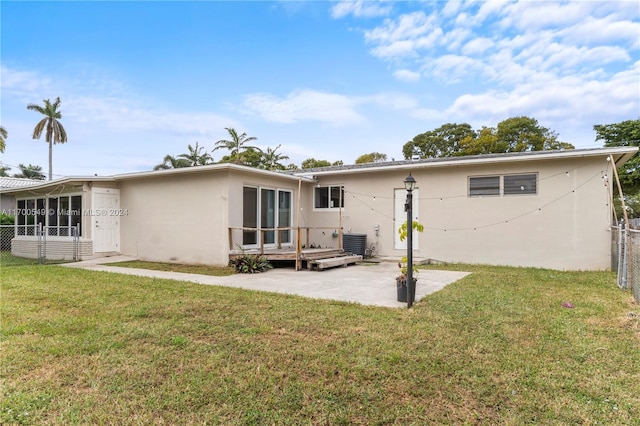 rear view of property featuring a patio area, a yard, and cooling unit