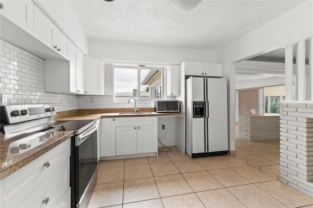 201 Entrada Dr, Hollywood, FL 33021 - kitchen featuring a sink, a textured ceiling, appliances with stainless steel finishes, and white cabinets