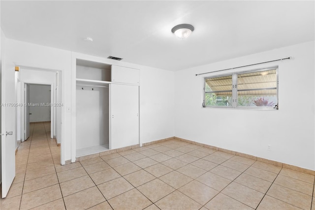 unfurnished bedroom with a closet and light tile patterned flooring