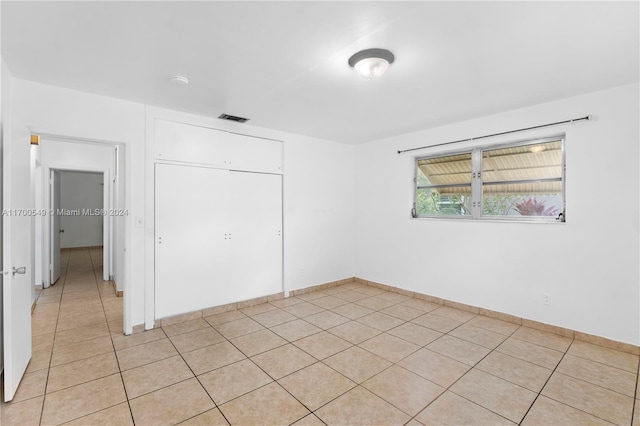 unfurnished bedroom featuring a closet and light tile patterned flooring