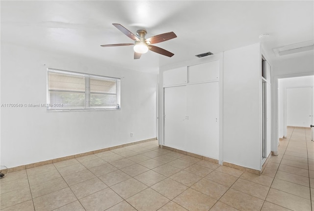 tiled spare room featuring ceiling fan