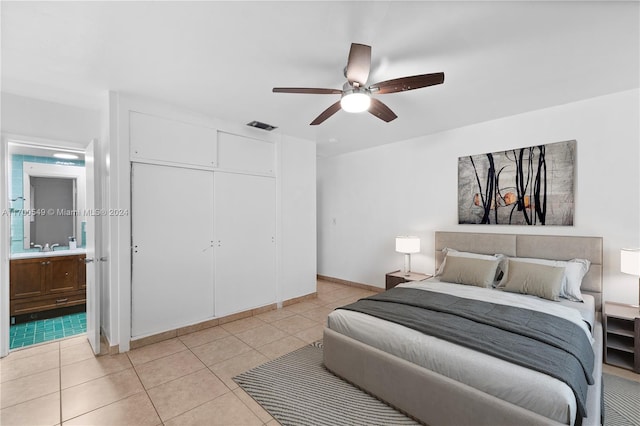 bedroom with ensuite bath, ceiling fan, a closet, and light tile patterned floors